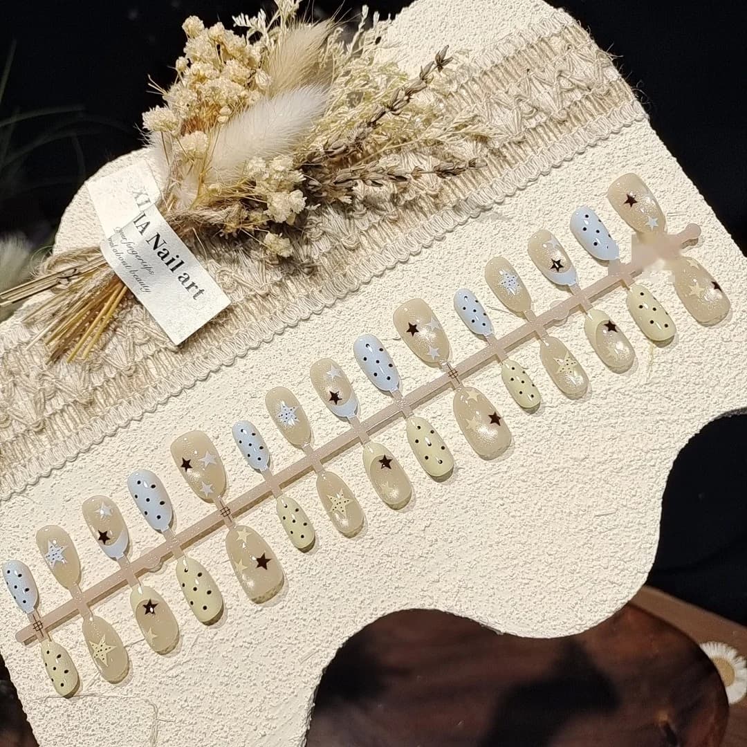ציפורניים מלאכותיות קצרות ואליפטיות עם טיפ צרפתי, נקודות, חרוזי זכוכית ואפקט עין החתול