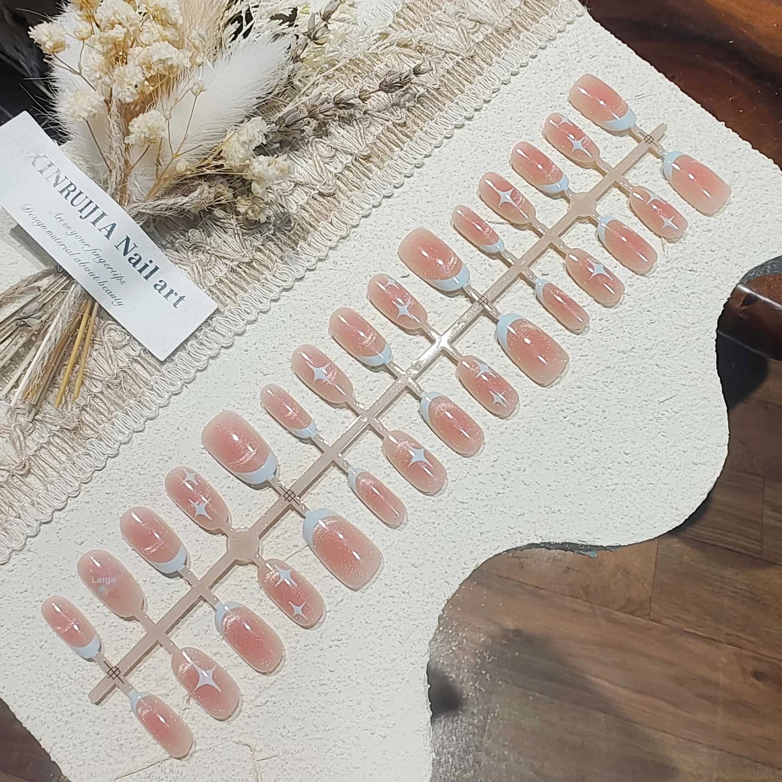 ציפורניים מלאכותיות קצרות ואובאליות בעיצוב עין חתול ושמיים זרועי כוכבים