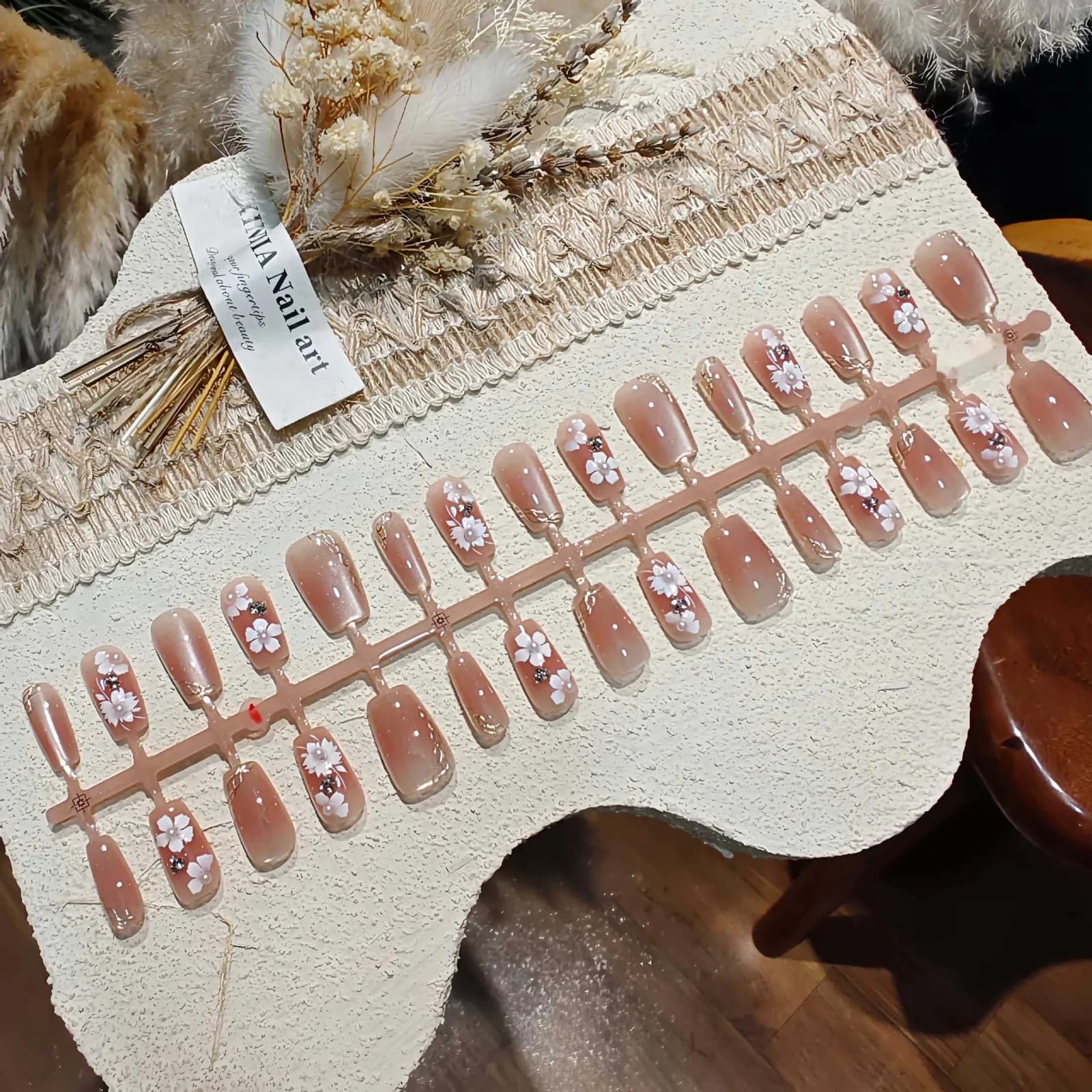 ציפורניים מלאכותיות בעין חתול עם פרחים, פנינים ואבני חן