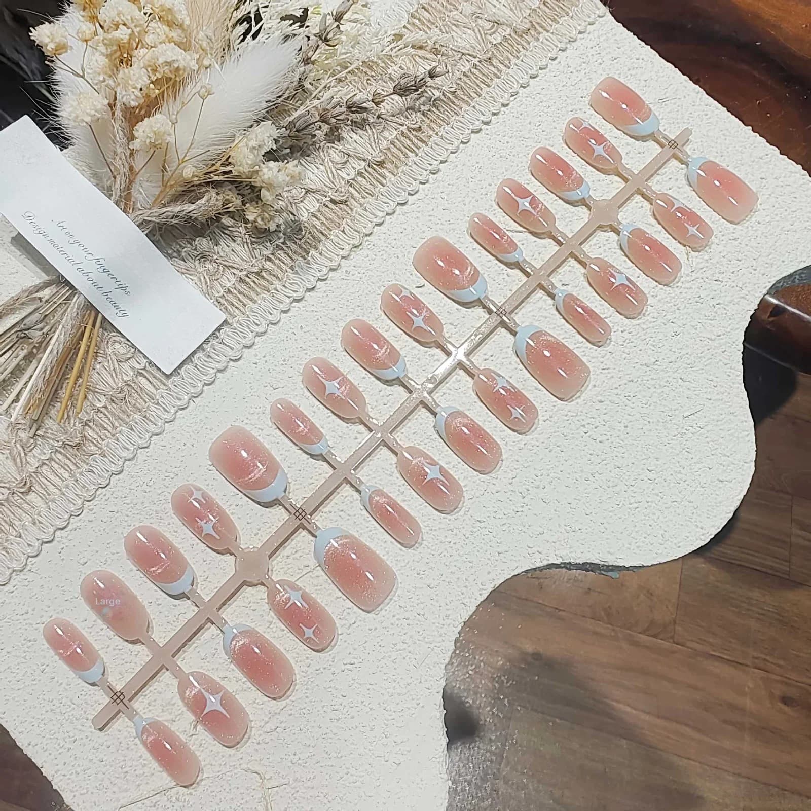 ציפורניים מלאכותיות קצרות ואובאליות בעיצוב עין חתול ושמיים זרועי כוכבים